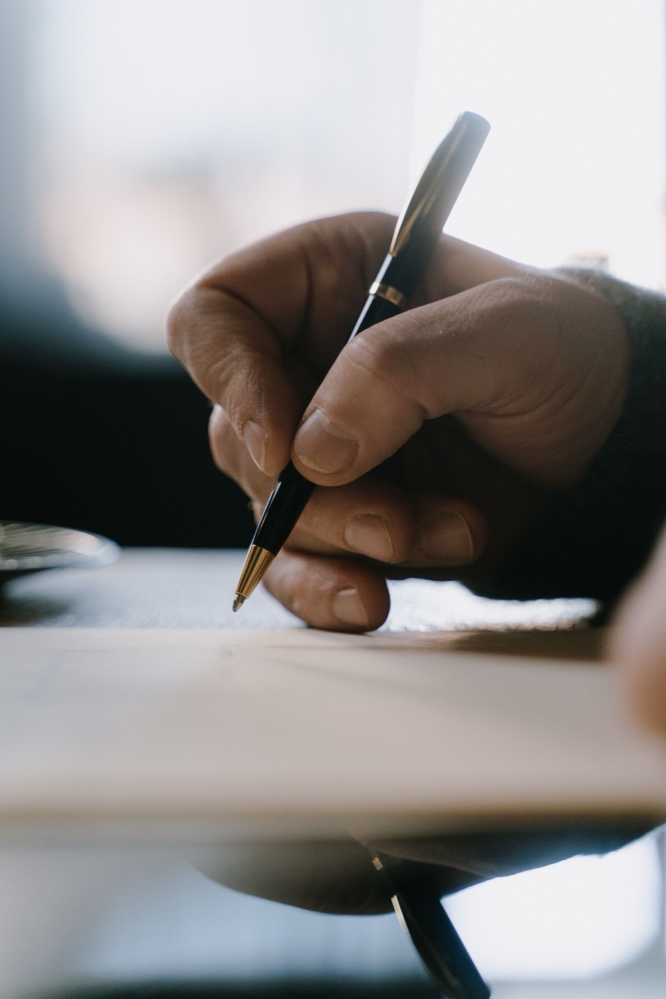 A hand writing with a pen on paper